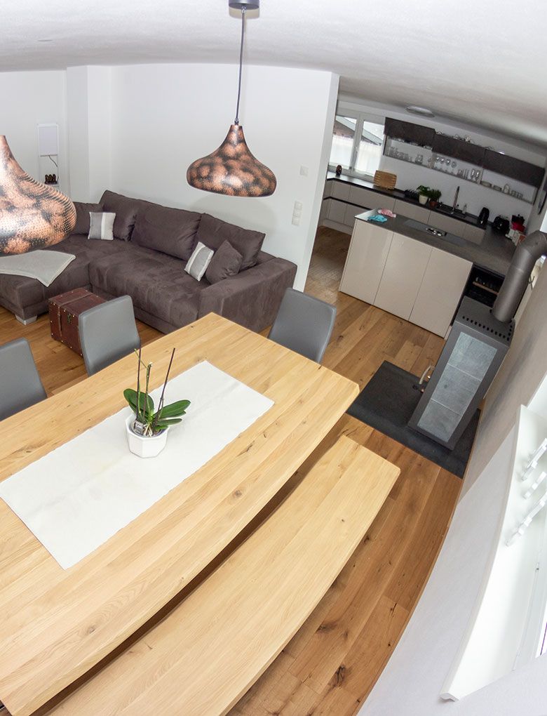 Wohnzimmeraufnahme mit Tisch und Couch sowie Küche